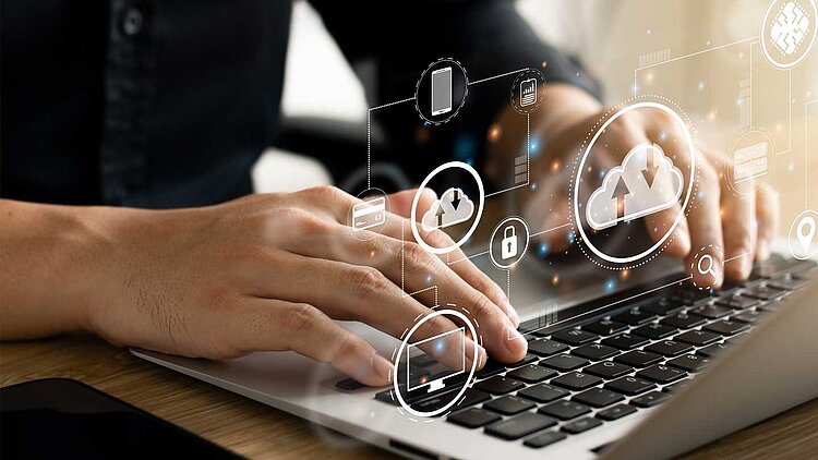 Erfolgsfaktor Cloud. Microsoft Dynamics 365 cloudbasiert. Bild mit Mensch, der vor einem Laptop sitzt. Grafisch dargestellt Cloud-Wolken schweben über dem Laptop.