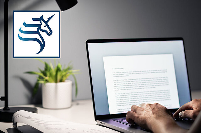 Mann tippt auf seinem Laptop einen Text ein.
